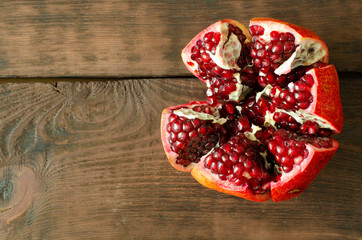 Opened pomegranate on wooden background with copy space.