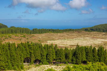 Fototapeta na wymiar Hills over fields. Terceira island in Azores with blue sky and clouds.