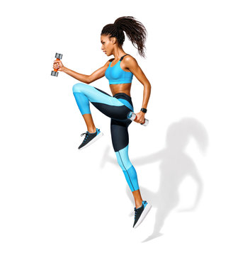 Sporty girl jumping with dumbbells. Photo of african american girl in fashionable sportswear on white background. Dynamic movement. Side view. Full length. Sports and healthy lifestyle