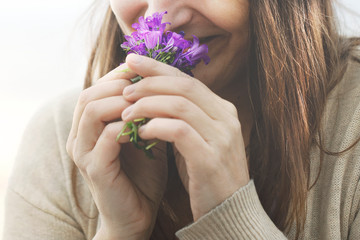happy woman sniffs a small bouquet of flowers, springtime