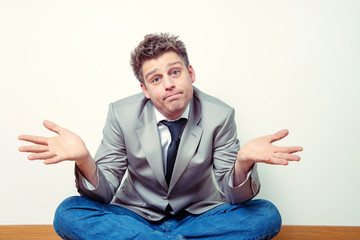 Expressive portrait of a man spreading his arms in a fatalistic way. Business concept.