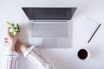 A woman worker cleaning with antivirus wet wipe a laptop and a working office desk before starting work for protect herself from bacteria and virus.