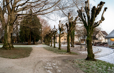 Foot path through Munkehagen park with scenic trees and playground equipment in winter season, Stavanger, Norway, December 2017