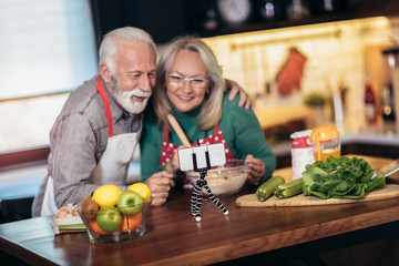 Senior couple making video call on phone in modern kitchen.Quarantine. Health concept.