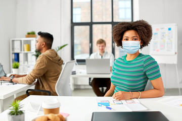 health, safety and pandemic concept - african american woman wearing protective medical mask for protection from virus at office
