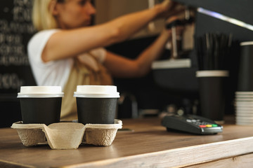 Fototapeta na wymiar Two cups of coffee and Female barista with coffee machine on background. 