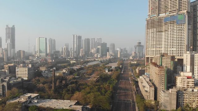 Dolly back drone shot of a large, vibrant, metropolitan Mumbai city India