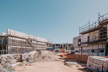 Construction site in progress, large heaps of soil and sand in forefront