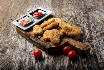 chicken nuggets with tomatoes on a rustic table