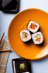 sushi on an orange plate in an overhead view