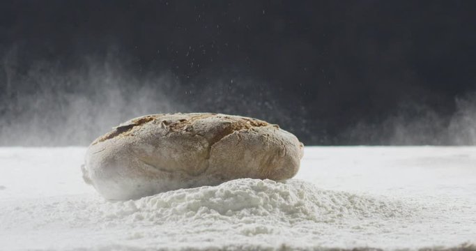 Bakery and cooking concept. Fresh bread with a splash falls into flour
