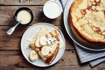 Thin pancakes, crepes with bananas and condensed milk.