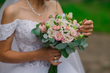 the bride holds a delicate wedding bouquet