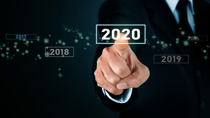 Fototapeta na wymiar Man standing and pointing hand with 2020 Visual Graphic on Light and star background. COPY SPACE. Business Concept : Market Uptrend and Forecast 2020