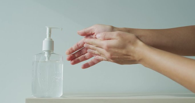Hand sanitizer alcohol gel rub clean hands hygiene prevention of coronavirus virus outbreak. Woman using bottle of antibacterial sanitiser soap. Slow motion on RED cinema camera.