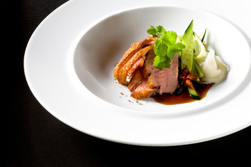 Pulled pork on a white dish, with fresh vegatables
