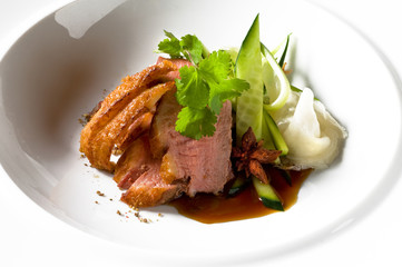 Pulled pork on a white dish, with fresh vegatables