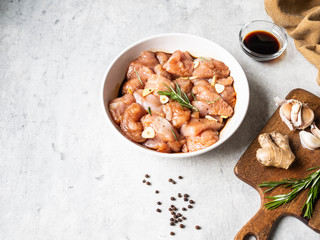 Raw diet marinated turkey meat with garlic, ginger and teriyaki sauce in a white bowl. Marinating meat for cooking barbecue. Top view