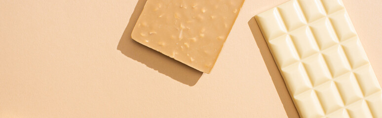 top view of delicious white chocolate bars on beige background, panoramic shot