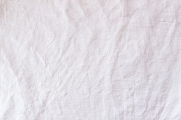Obraz na płótnie Canvas Rough crumpled white linen textile background texture front view.