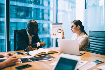 Woman showing chart to colleague in office
