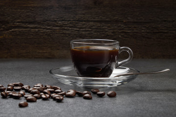 glass Cup of coffee beans with cinnamon and sugar on a dark wooden background