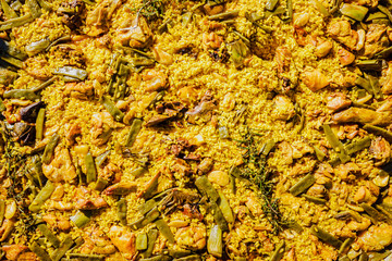 Yellow rice with meat and vegetables, Valencian paella, typical dish of Spanish gastronomy for tourists.