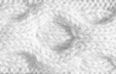 Texture pattern knitting with acrylic thread. Manual work with knitting needles, white background of wool.