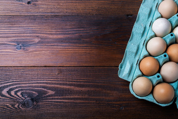 huevos en un contenedor de carton sobre un fondo de madera