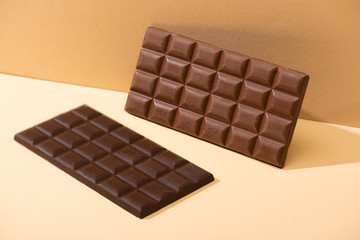 sweet delicious dark, milk chocolate bars on beige background