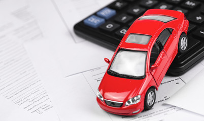 red car and calculator closeup on the paper form
