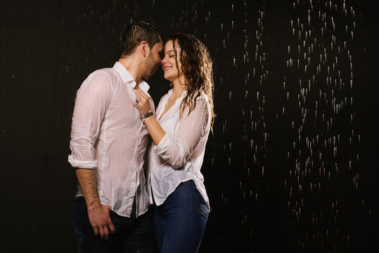 Beautiful couple under the rain at night time, romantic view, walking and kissing couple.