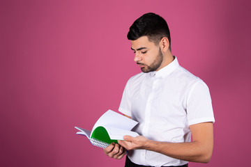 Student and Lessons. Attractive guy. Pink background.