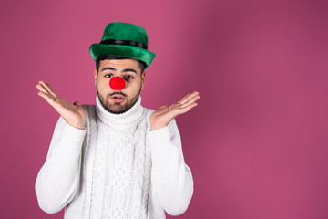 Funny young clown. Pink background.