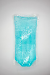 Coronavirus hand sanitizer gel to wash hands for flu virus prevention. Blue gel in clear plastic bag on white