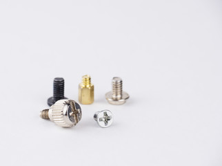 Fototapeta premium Metal screws of different sizes and different colors on a white background.