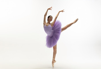 Graceful classic ballerina dancing, posing isolated on white studio background. Bright purple tutu....