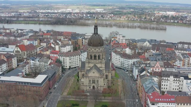 Aerial / drone panorama rotating cinematic shot of the christus church in mainz with the river rhine in the background 30p