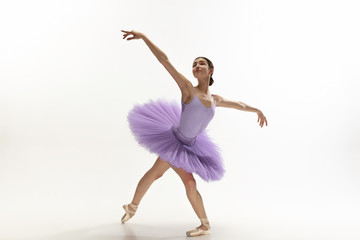 Graceful classic ballerina dancing, posing isolated on white studio background. Bright purple tutu. The grace, artist, movement, action and motion concept. Looks weightless, flexible. Fashion, style.