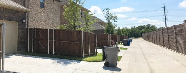 Panoramic concrete back alley with trash containers of new residential housing in Allen, Texas, USA