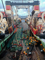 Fishing with a trawl. A large trawl with fish was dragged onto the deck of the ship