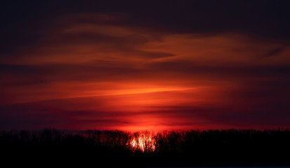 Fototapeta na wymiar A winter sunrise with a red sky and clouds in Ottawa, Canada