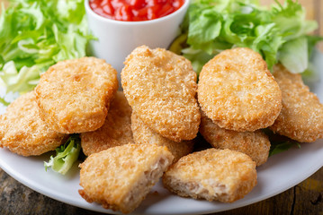 chicken nuggets with ketchup on a plate on a rustic table