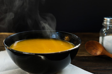 Steaming of hot pumkin soup in white bowl served on wooden table ready to eat. Hot food is good for healthy 