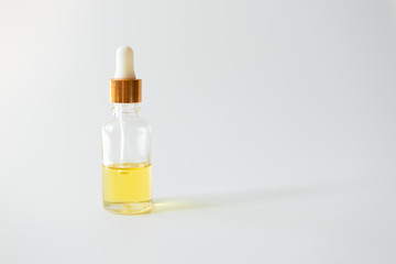 Oil vitamin serum in glass bottle on light background, copy space. Skincare beauty product