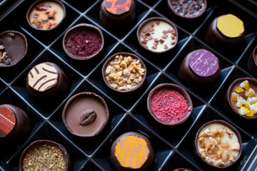 Various of sweet confectionery with chocolate candies and pralines. Handmade box of chocolates. Realistic chocolate set, delicious dessert pattern.