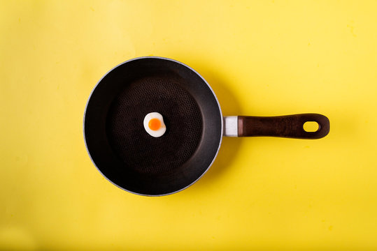 egg-shaped swallow on a frying pan and with a yellow background