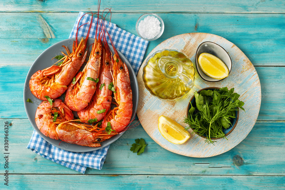 Wall mural top view of blue color dining table with cooked red prawns and ingredients