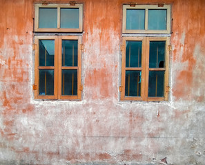 Fototapeta na wymiar Architectural Details Vintage Window with Peeling Paint in orange. Old vintage window of house old fashion design classic on rustic painted concrete wall background