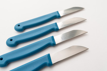 four sharp knives with blue plastic handle on white background